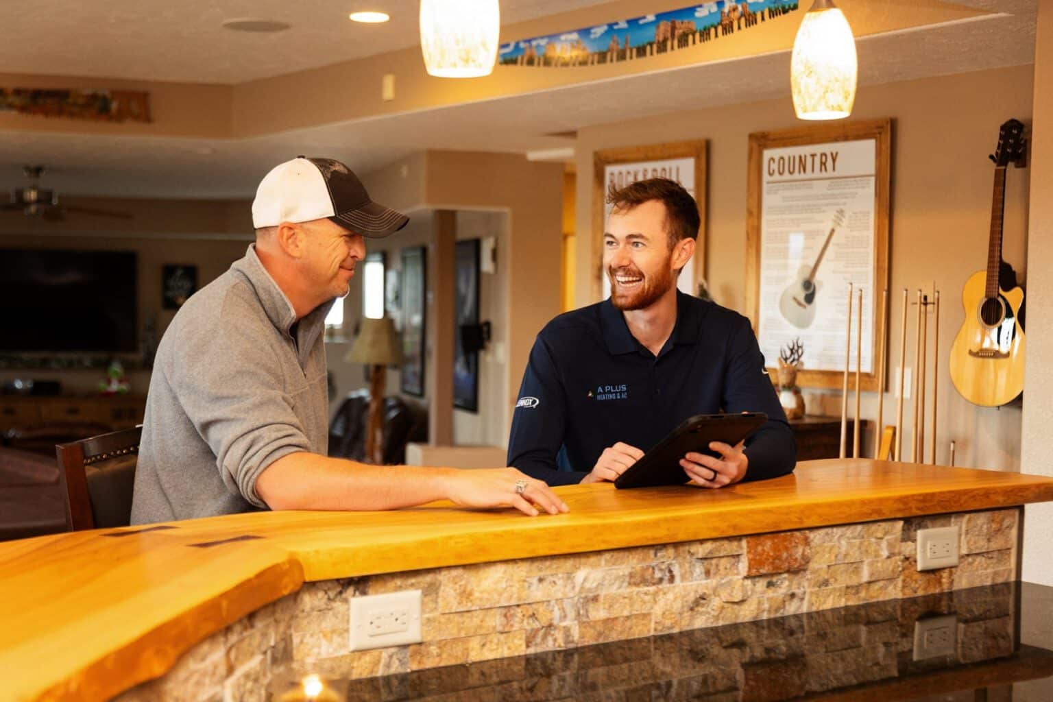 A Plus owner Zach Karre talking with a homeowner at their kitchen counter